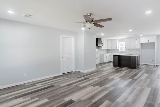 unfurnished living room with ceiling fan, light hardwood / wood-style flooring, and sink