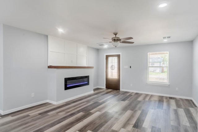 unfurnished living room featuring ceiling fan, a fireplace, and light hardwood / wood-style flooring