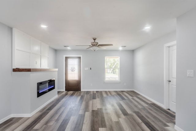 unfurnished living room with hardwood / wood-style floors and ceiling fan