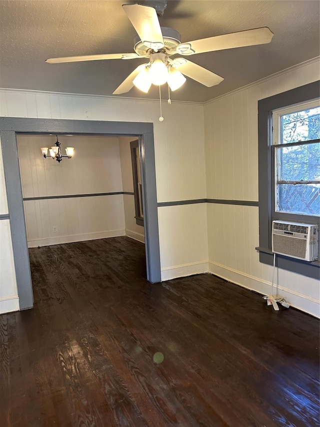 unfurnished room featuring cooling unit, a textured ceiling, ceiling fan with notable chandelier, crown molding, and dark hardwood / wood-style flooring