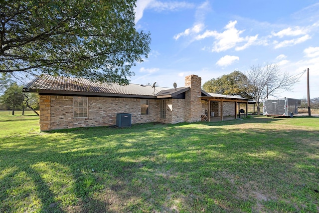 rear view of property with a trampoline, a lawn, and central AC