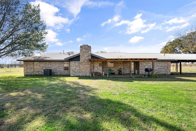 back of house featuring cooling unit, a patio, and a yard