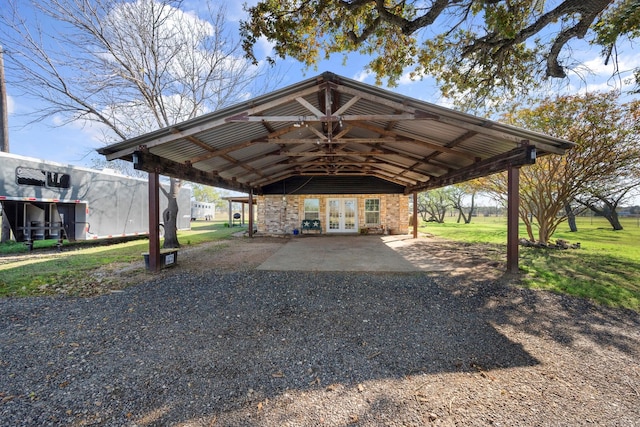 view of vehicle parking featuring french doors and a yard