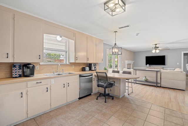 kitchen with decorative backsplash, ceiling fan with notable chandelier, pendant lighting, crown molding, and sink