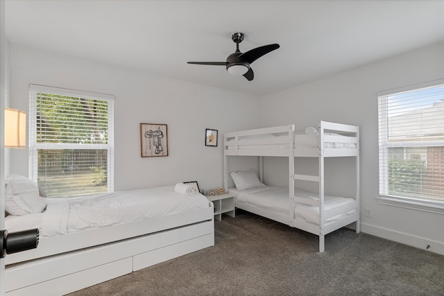 bedroom with dark carpet, multiple windows, and ceiling fan