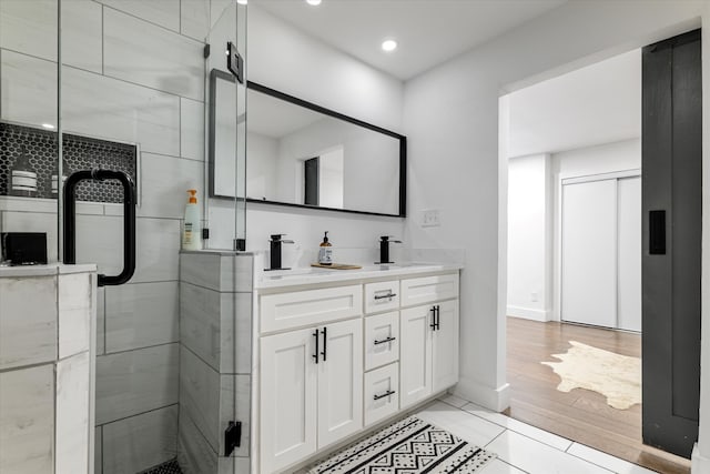 bathroom featuring hardwood / wood-style flooring, vanity, and an enclosed shower