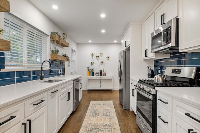 kitchen with stainless steel appliances, sink, dark hardwood / wood-style flooring, and white cabinetry