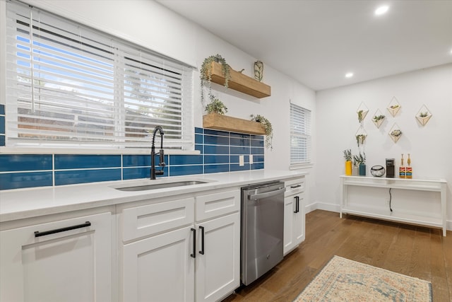 kitchen featuring sink, white cabinetry, decorative backsplash, dark hardwood / wood-style flooring, and stainless steel dishwasher