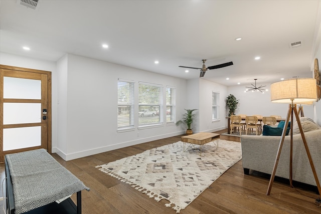 living room featuring ceiling fan and dark wood-type flooring