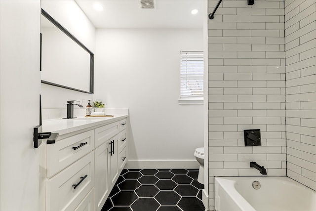 full bathroom with tile patterned flooring, tiled shower / bath, vanity, and toilet