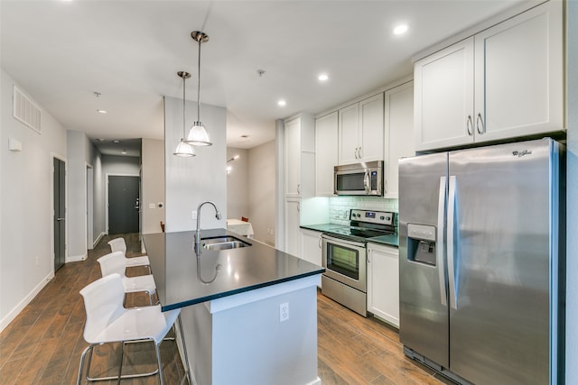 kitchen with appliances with stainless steel finishes, sink, dark hardwood / wood-style flooring, and white cabinetry