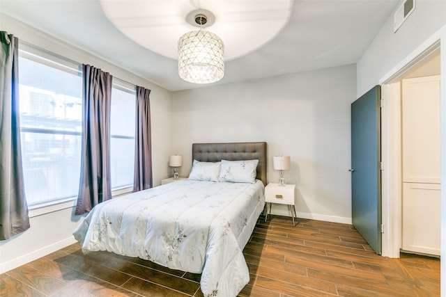 bedroom with dark hardwood / wood-style flooring