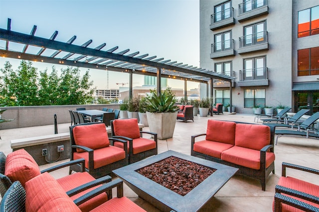 view of patio featuring a balcony and an outdoor living space with a fire pit