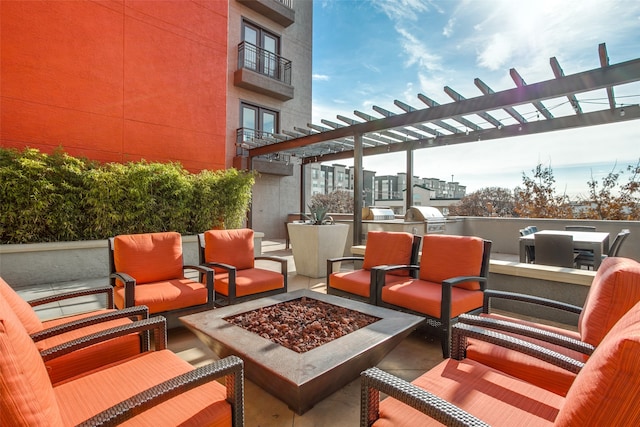 view of patio featuring a grill, an outdoor living space with a fire pit, and exterior kitchen