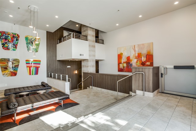 kitchen with decorative light fixtures, a towering ceiling, and light tile patterned floors