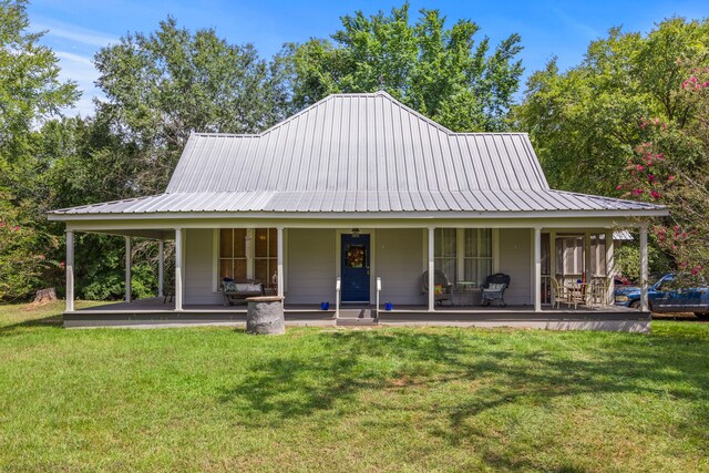 farmhouse with covered porch and a front yard