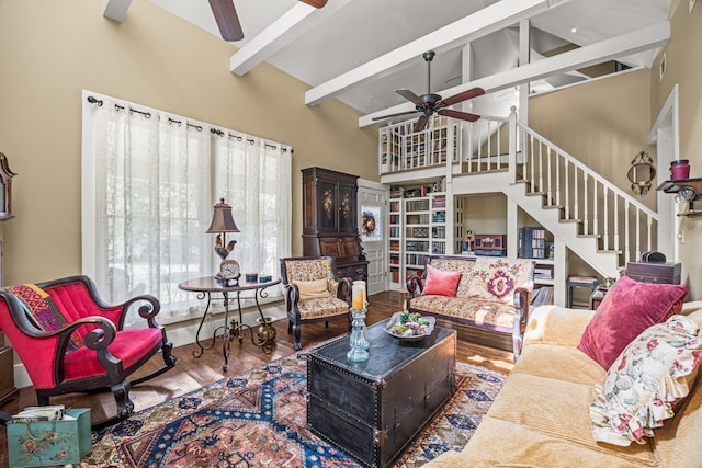 living room featuring wood-type flooring, beamed ceiling, ceiling fan, and high vaulted ceiling