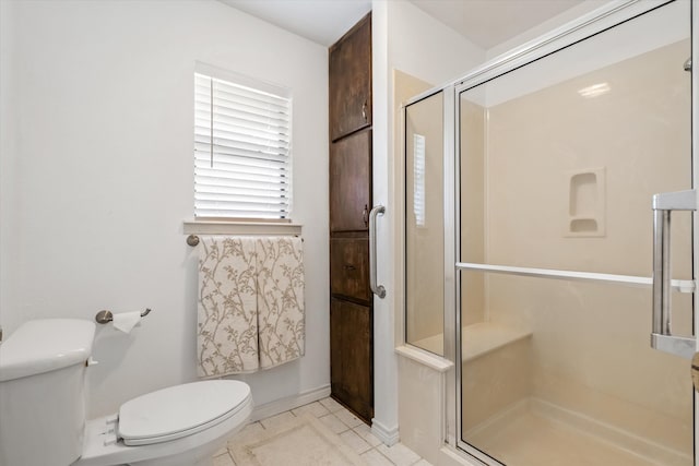 bathroom with a shower with shower door and toilet