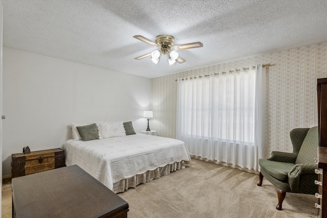 carpeted bedroom featuring ceiling fan and a textured ceiling