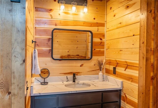 bathroom featuring wooden walls and vanity