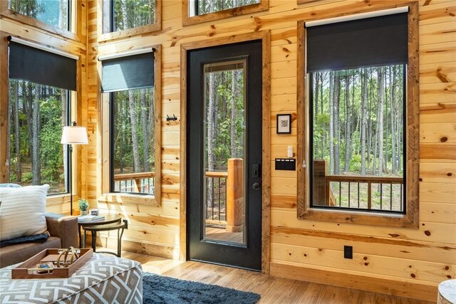 doorway to outside featuring wood walls and wood finished floors