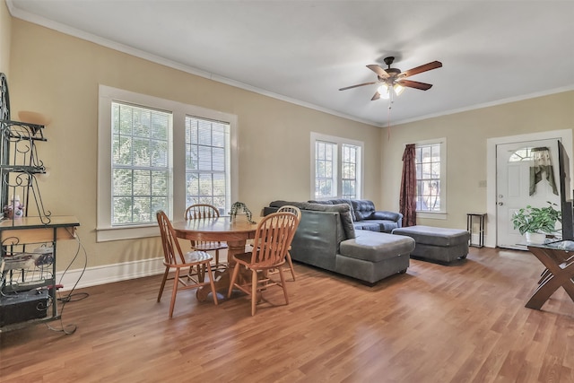 dining space with wood-type flooring, crown molding, and ceiling fan