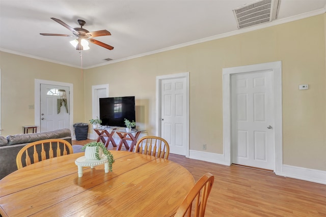 dining space with ceiling fan, light wood-type flooring, and crown molding