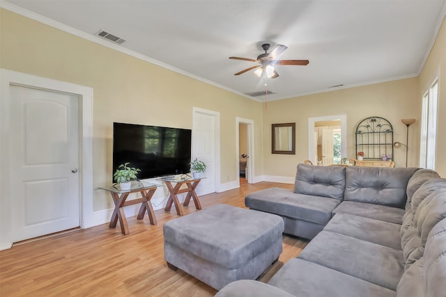 living room with ornamental molding, ceiling fan, and light hardwood / wood-style flooring