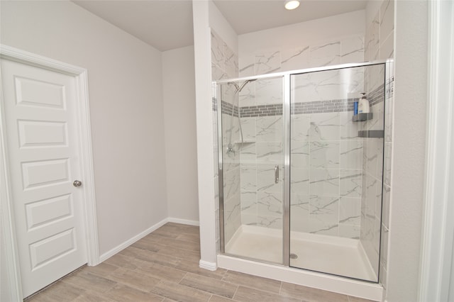 bathroom featuring wood-type flooring and a shower with shower door