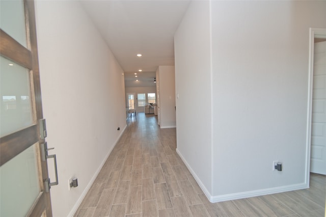 hallway with light hardwood / wood-style floors