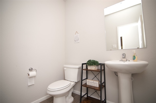 bathroom with hardwood / wood-style floors and toilet