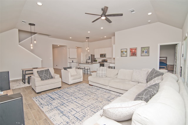 living room featuring light wood-type flooring, vaulted ceiling, and ceiling fan