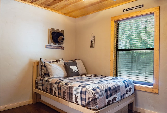 bedroom with dark wood-type flooring and wooden ceiling