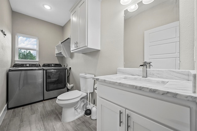 bathroom with vanity, toilet, and washing machine and clothes dryer