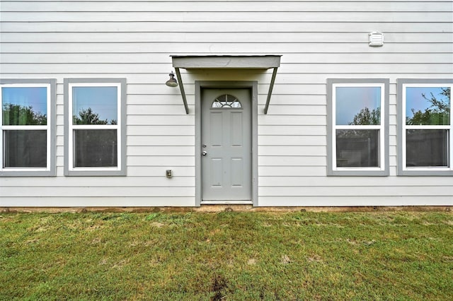 view of exterior entry featuring a yard