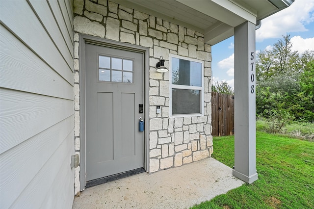 property entrance featuring a lawn