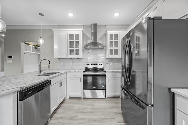 kitchen featuring appliances with stainless steel finishes, white cabinetry, wall chimney exhaust hood, and sink