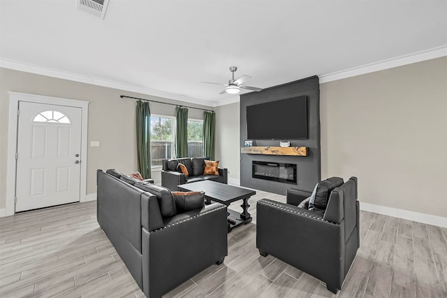 living room with ceiling fan, a large fireplace, crown molding, and light hardwood / wood-style flooring