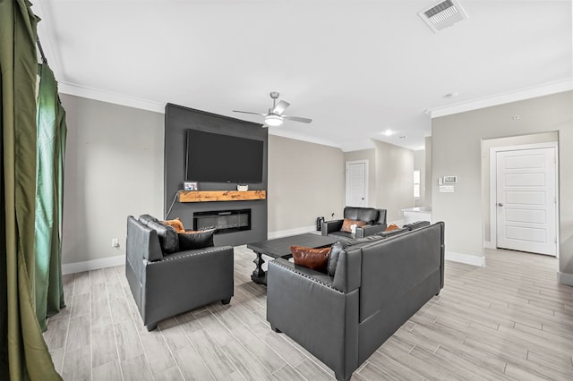 living room featuring a large fireplace, ceiling fan, and crown molding