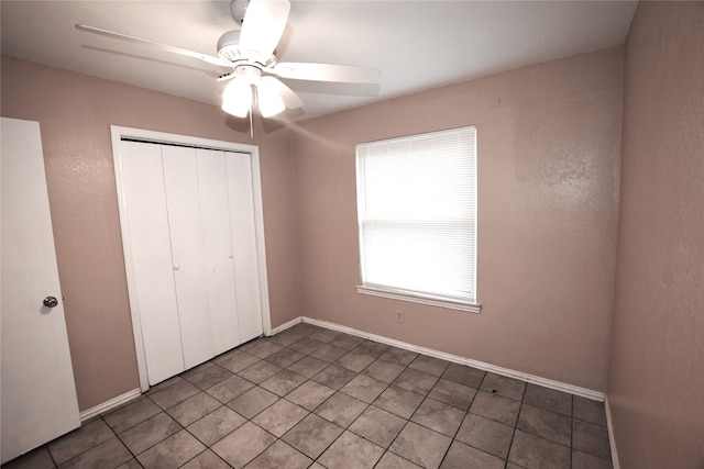 unfurnished bedroom featuring tile patterned floors, ceiling fan, and a closet