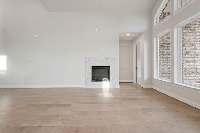 unfurnished living room with a fireplace and light wood-type flooring