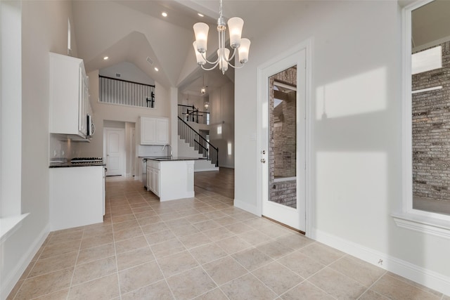 kitchen featuring decorative light fixtures, a center island, light tile patterned floors, a notable chandelier, and white cabinets