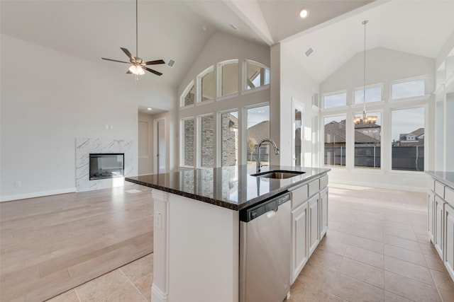 kitchen featuring sink, a kitchen island with sink, stainless steel dishwasher, and white cabinets