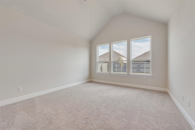 spare room with lofted ceiling and light carpet