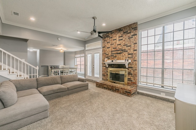 carpeted living room featuring ceiling fan, a textured ceiling, and ornamental molding