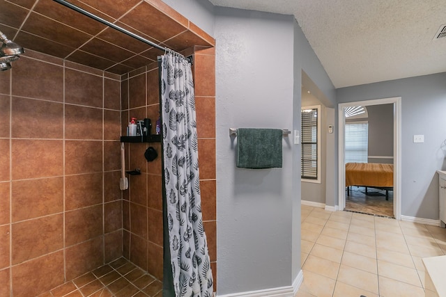 205 Benwynd Dr, Mesquite, TX 75149 - bathroom with tiled shower, tile patterned floors, vaulted ceiling, and a textured ceiling