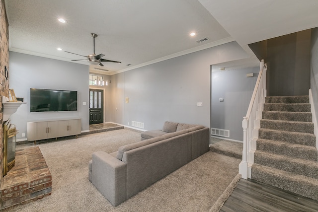 living room with a fireplace, ceiling fan, dark hardwood / wood-style flooring, and ornamental molding