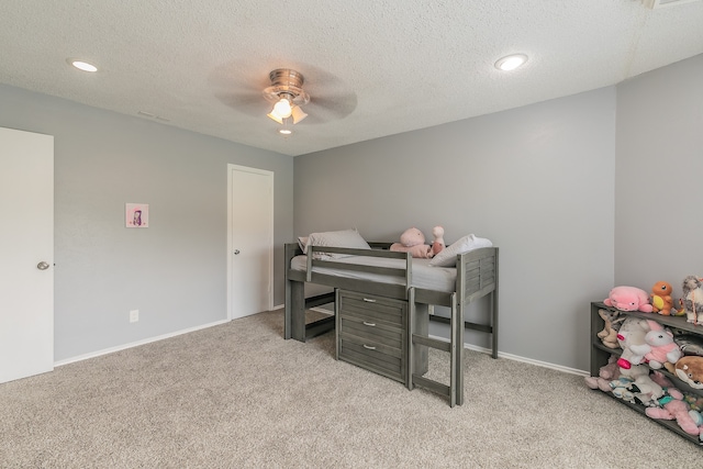 carpeted bedroom featuring a textured ceiling and ceiling fan