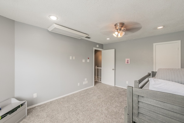 bedroom featuring a textured ceiling, light carpet, and ceiling fan