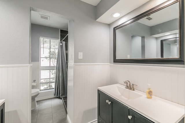 bathroom with tile patterned flooring, vanity, and toilet